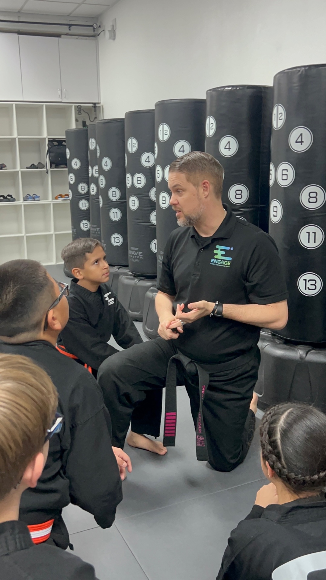 Coach guiding a young student at Engage Lifestyle Martial Arts in Henderson