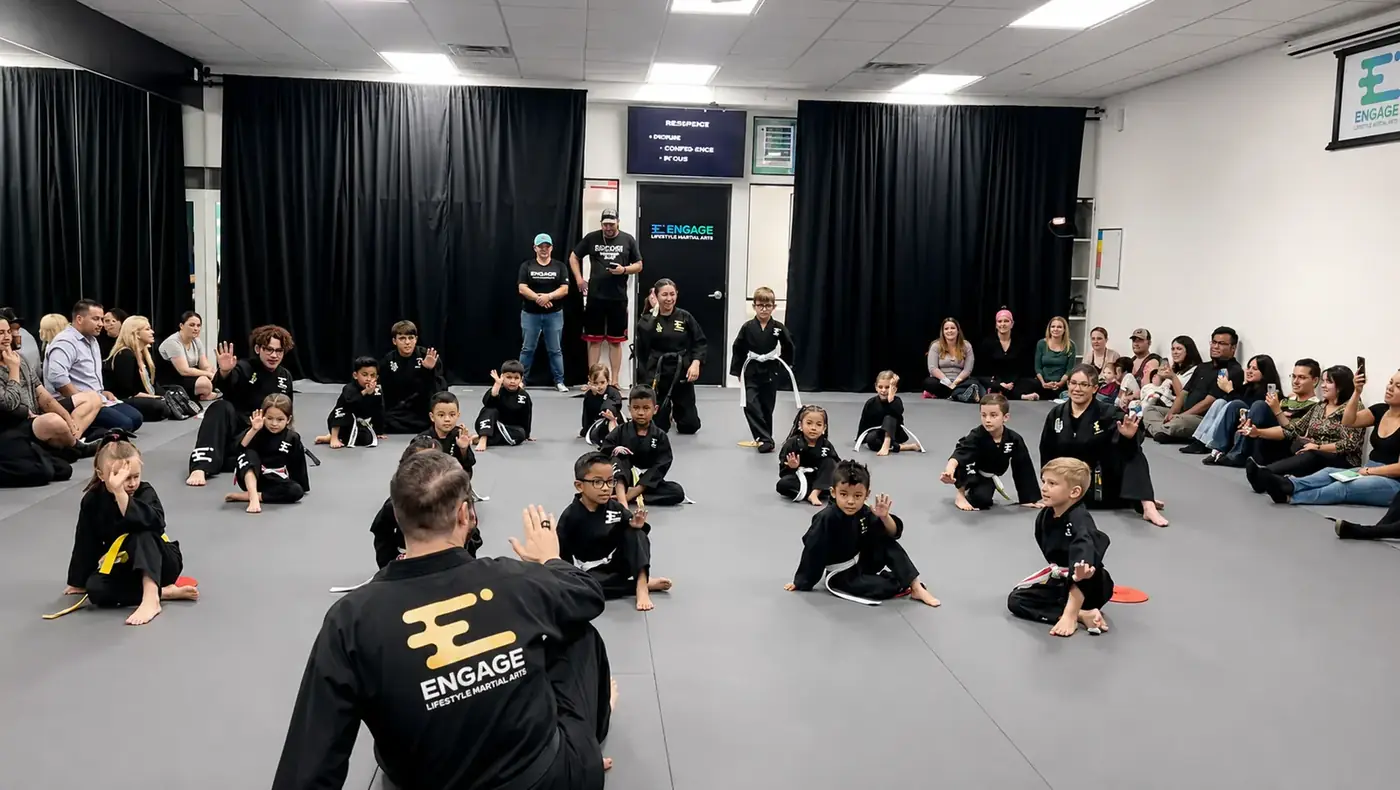 Coach kneeling at eye-level with young Engage students in a focused Henderson dojo class