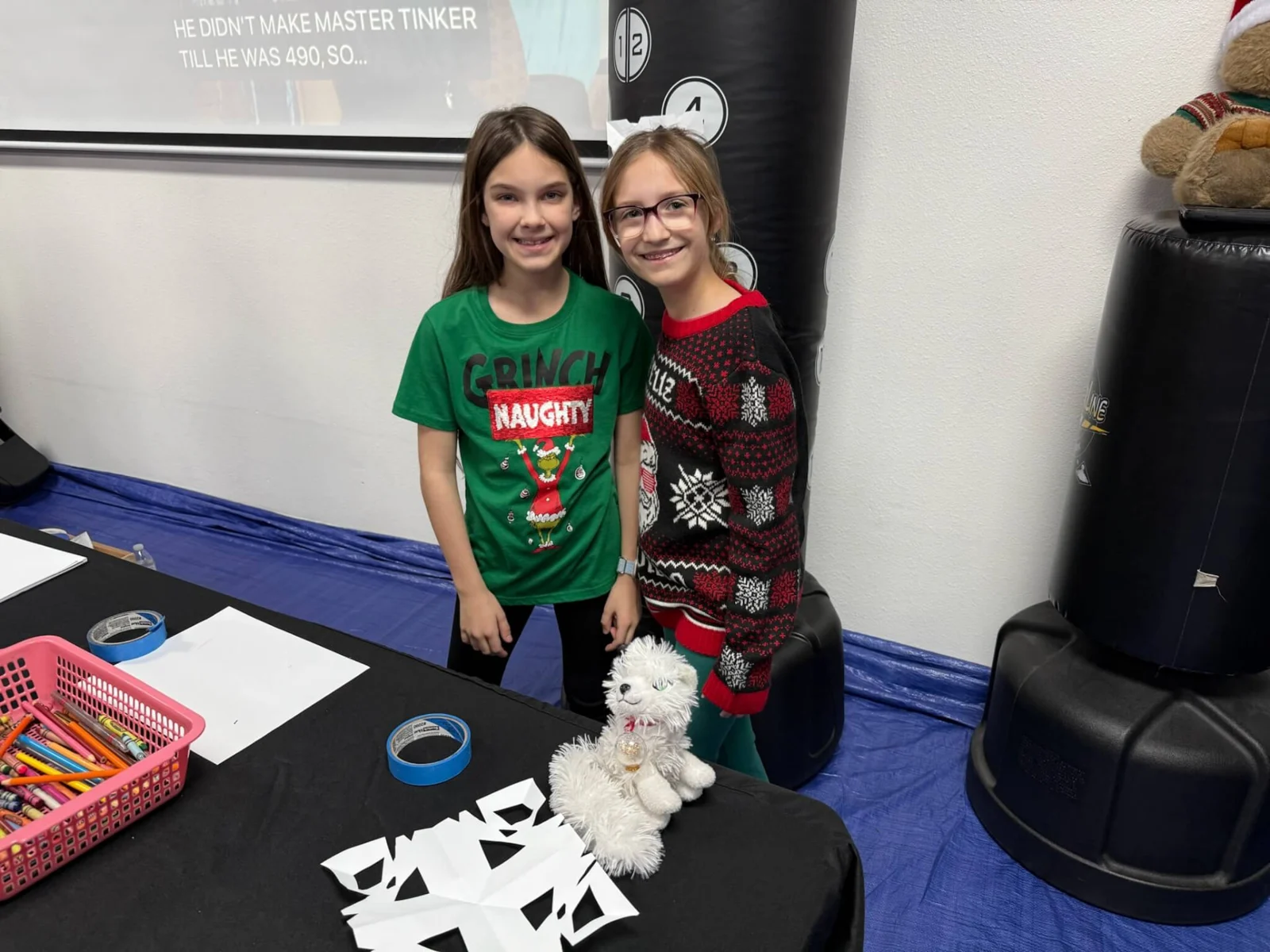 Two children smiling beside their winter crafts at Engage